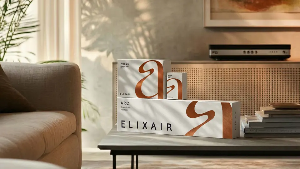 Elix Air boxes for PULSE, WAVE and ARC with sweeping copper monograms, on a coffee table